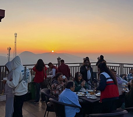 Guests enjoying a Sunset Hi-Tea on a deck with a stunning mountain view at Ojaswi Resort.
